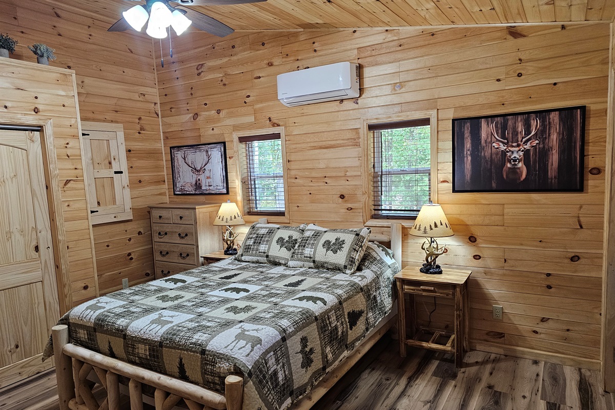 Drift off beneath cabin-style quilts and soft lamplight — a romantic retreat tucked in the trees.