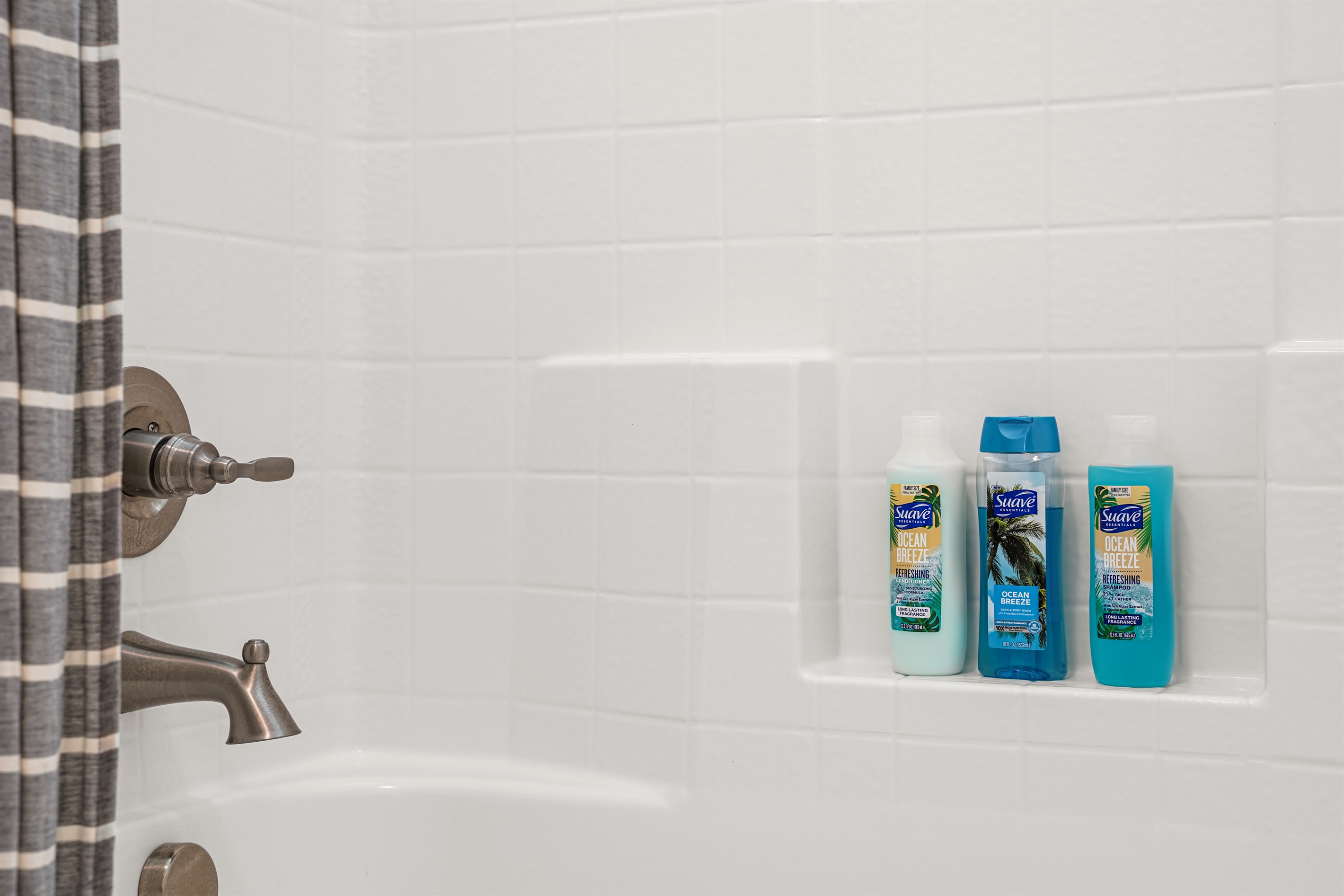 Clean shower with modern tiling and complimentary toiletries provided.