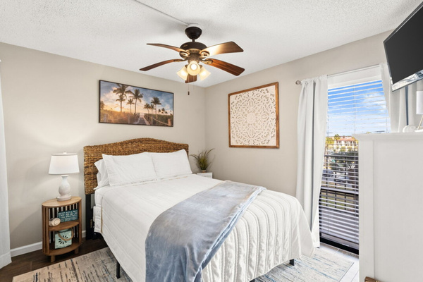 Guest bedroom with a queen bed, clothing storage, ceiling fan, and smart TV