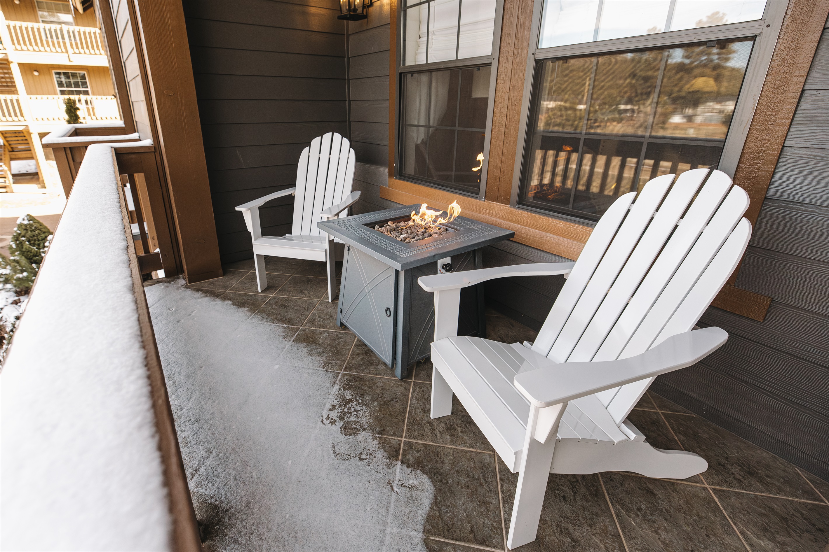 Private covered balcony with fire table and Adirondack seating—perfect for snowy mornings or evening wine. A cozy mountain retreat for couples and families enjoying fresh air in Pinetop year-round.