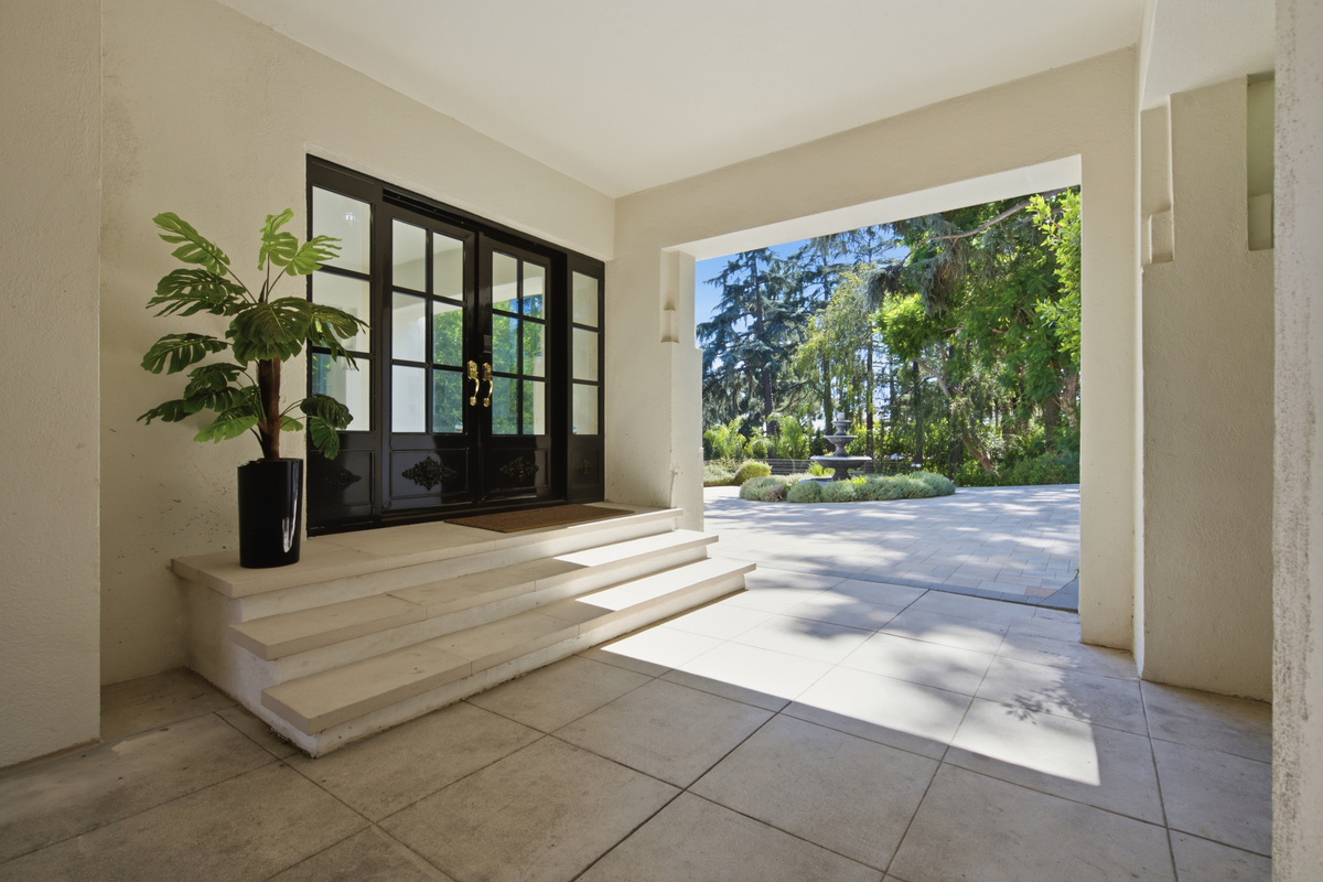 Welcomes guests into the spacious area, complete with comfortable seating and lush nature views.