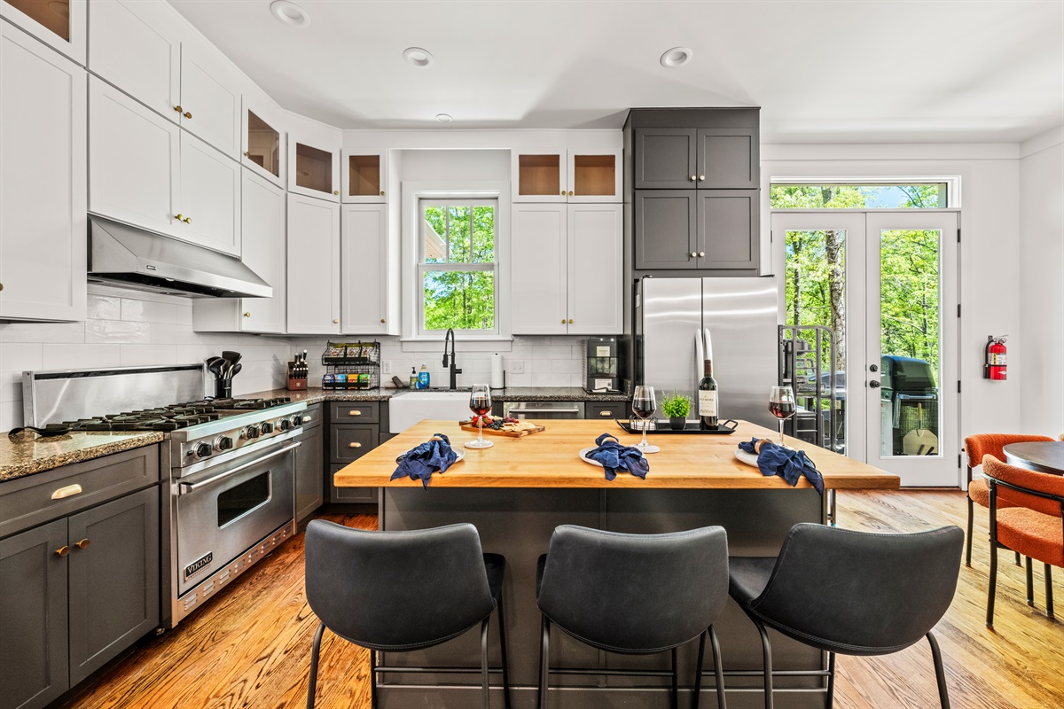 This fully equipped kitchen features high-end appliances, spacious butcher block island seating for three, and beautiful forest views — the perfect space to prep, gather, and graze.