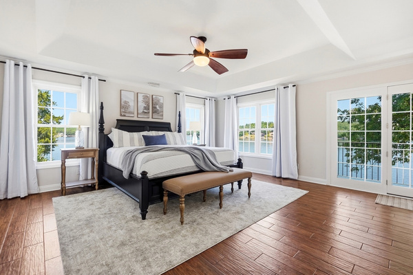Welcome to the primary suite; king bed, tons of natural light and Lake Tillery right outside your windows.
