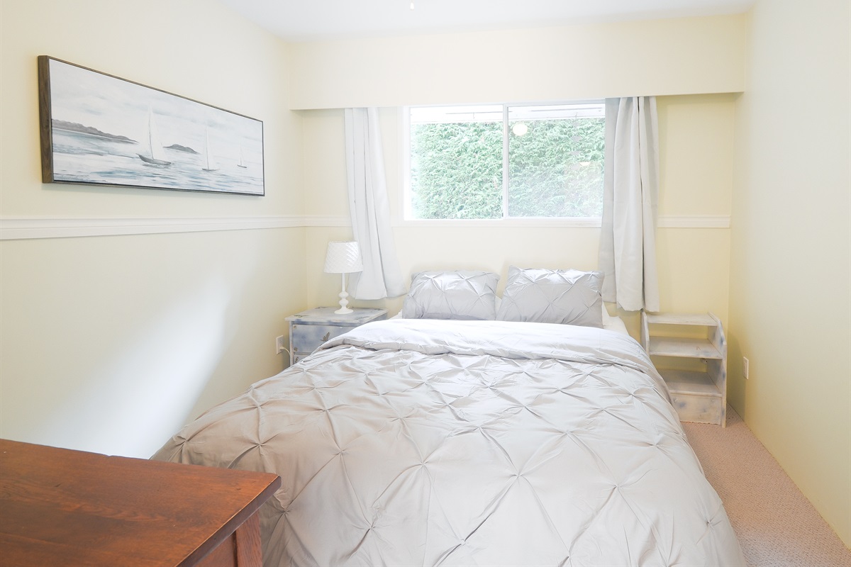 Second bedroom with queen bed and natural light