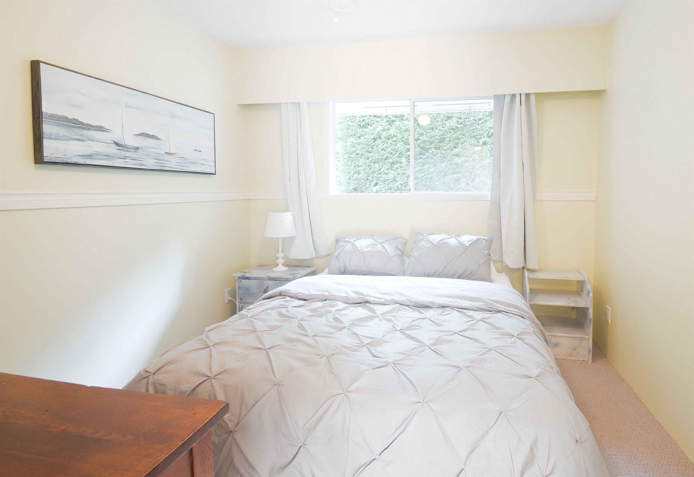 Second bedroom with queen bed and natural light