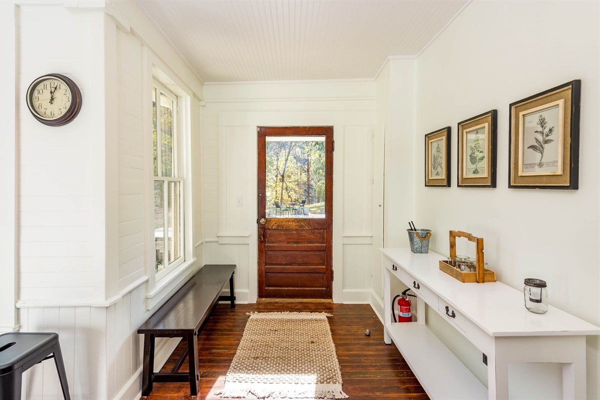 Backdoor entry hall leads to outdoor patio with hot tub and grill