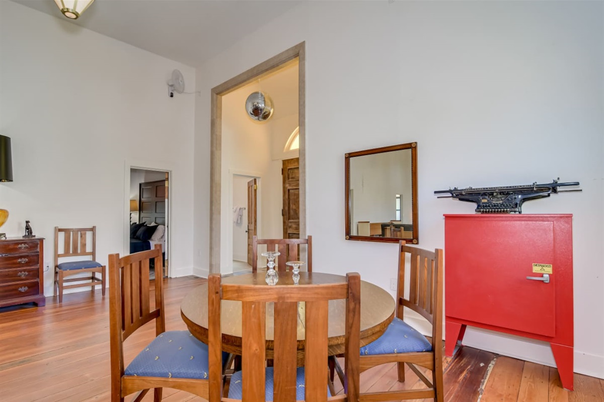 Dining and lounge area with cathedral windows and wood floors.