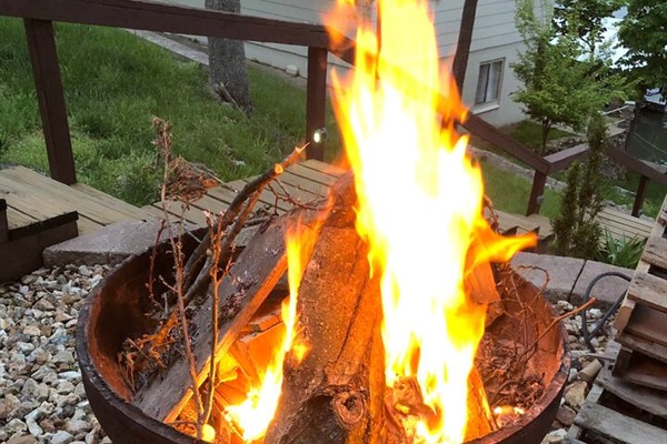Outdoor wood firepit next to the hot tub with the deck providing natural seating areas. 
