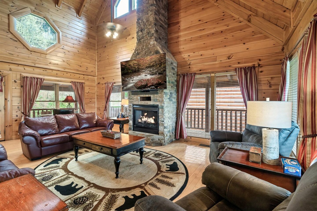 Living room with 75" TV. Larger couch contains a pull out sofa bed.(Fireplace is electric and for decorative purposes only).