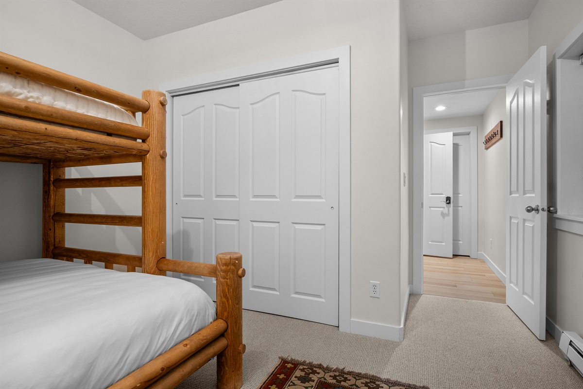 The bunk room has comfortable bedding and a spacious closet.