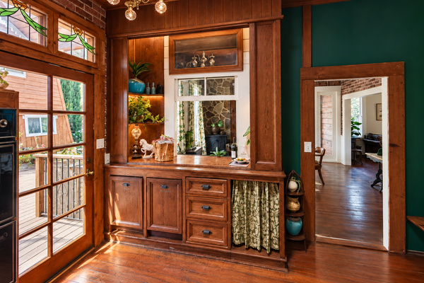 Designed to keep the cook in the heart of things: the kitchen connects to the dining room through a pass-through bar with operable window (part of the original house), Door opens to the back yard. High function, vintage soul.