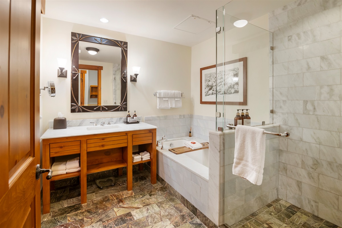 The luxurious bathroom includes a large custom shower and separate tub for ultimate relaxation after a day on the slopes