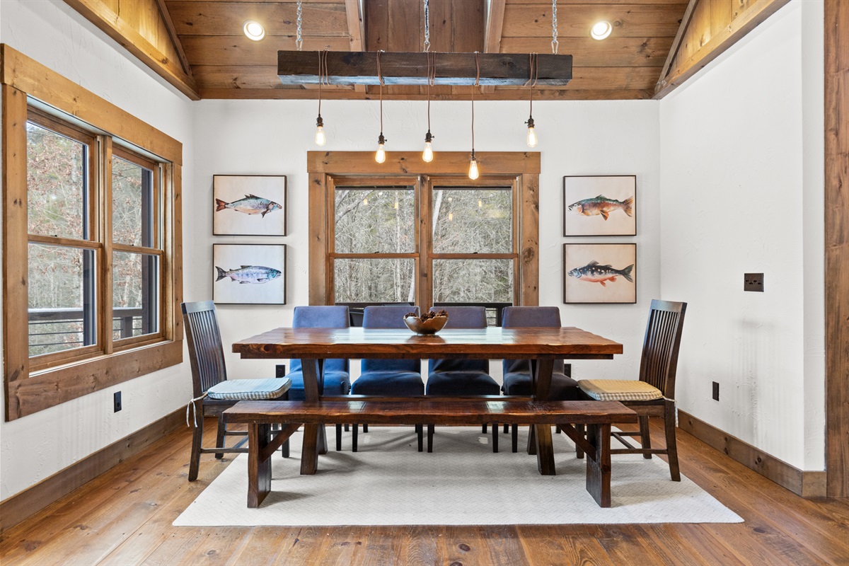 The dining area offers a spacious table and beautiful natural light, creating the perfect setting for meals and family game nights.