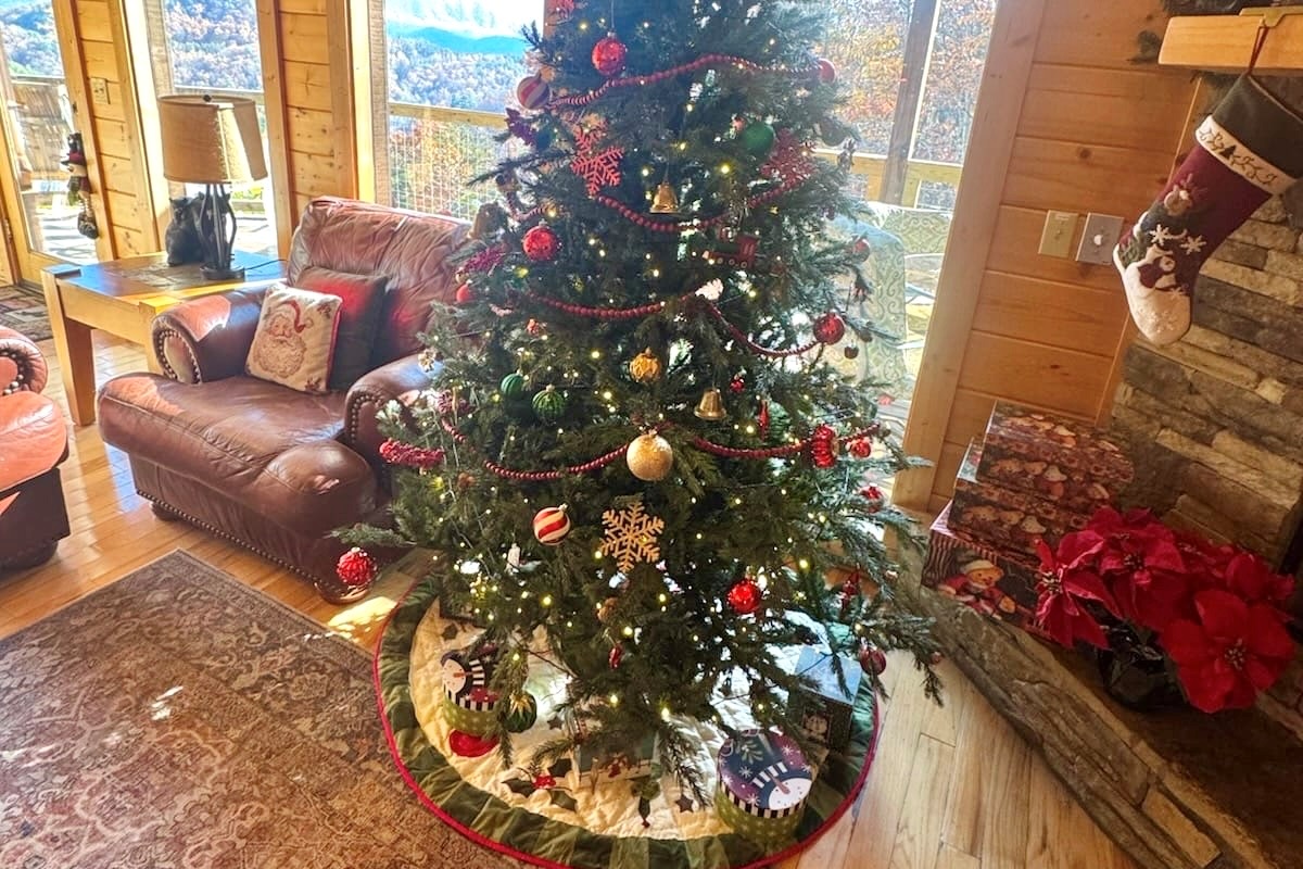 Cozy up by the crackling fireplace beside a beautifully decorated Christmas tree, where twinkling lights and stockings bring the cabin’s holiday spirit to life.