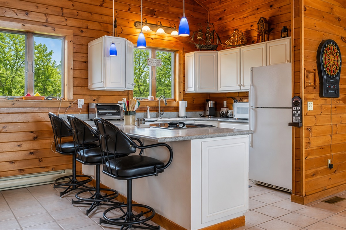 Enjoy a spacious and modern kitchen with sleek black bar stools, perfect for casual dining and socializing.