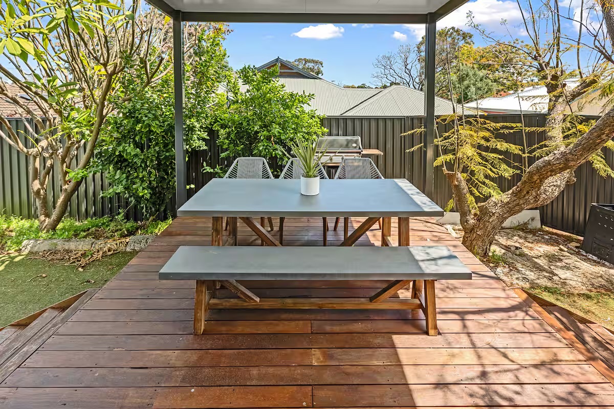 A covered entertainment area with barbecue and outdoor dining gives Sasha’s Cottage on the Hill a useful second living space.