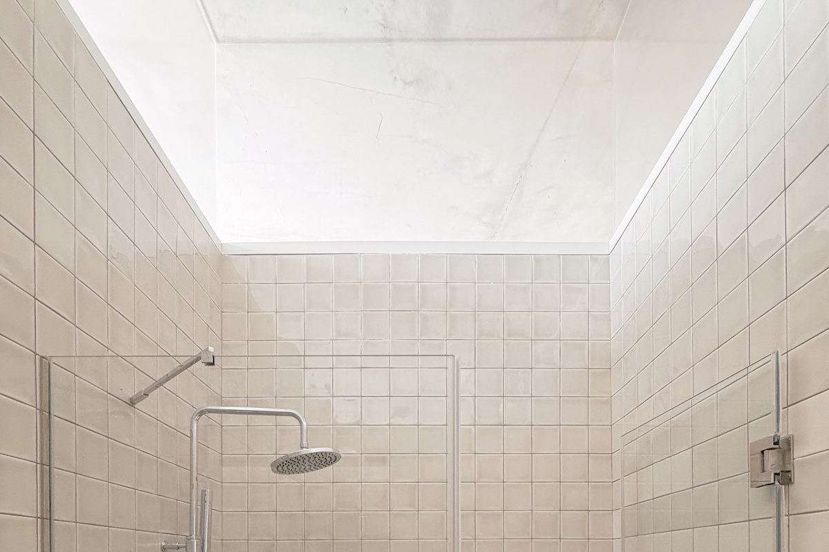 Shower with upper glass surround for natural light.