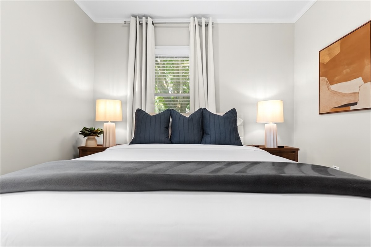 Relaxing queen bedroom with soft linens and natural light