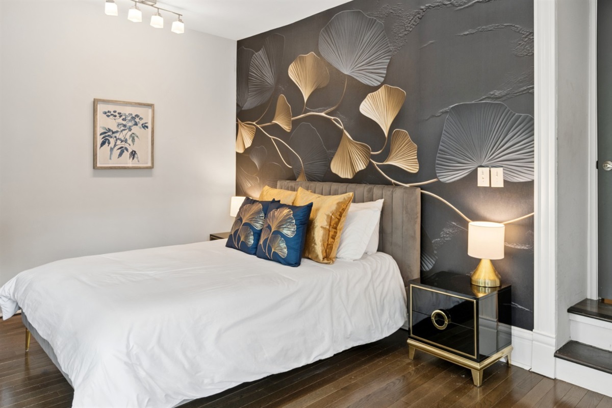 The second-floor guest bedroom features a comfortable queen bed and designer touches throughout.