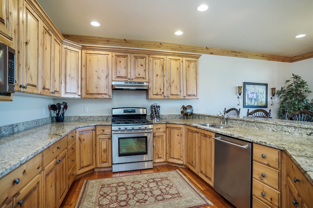 Fully equipped kitchen with natural wood cabinetry and modern appliances.