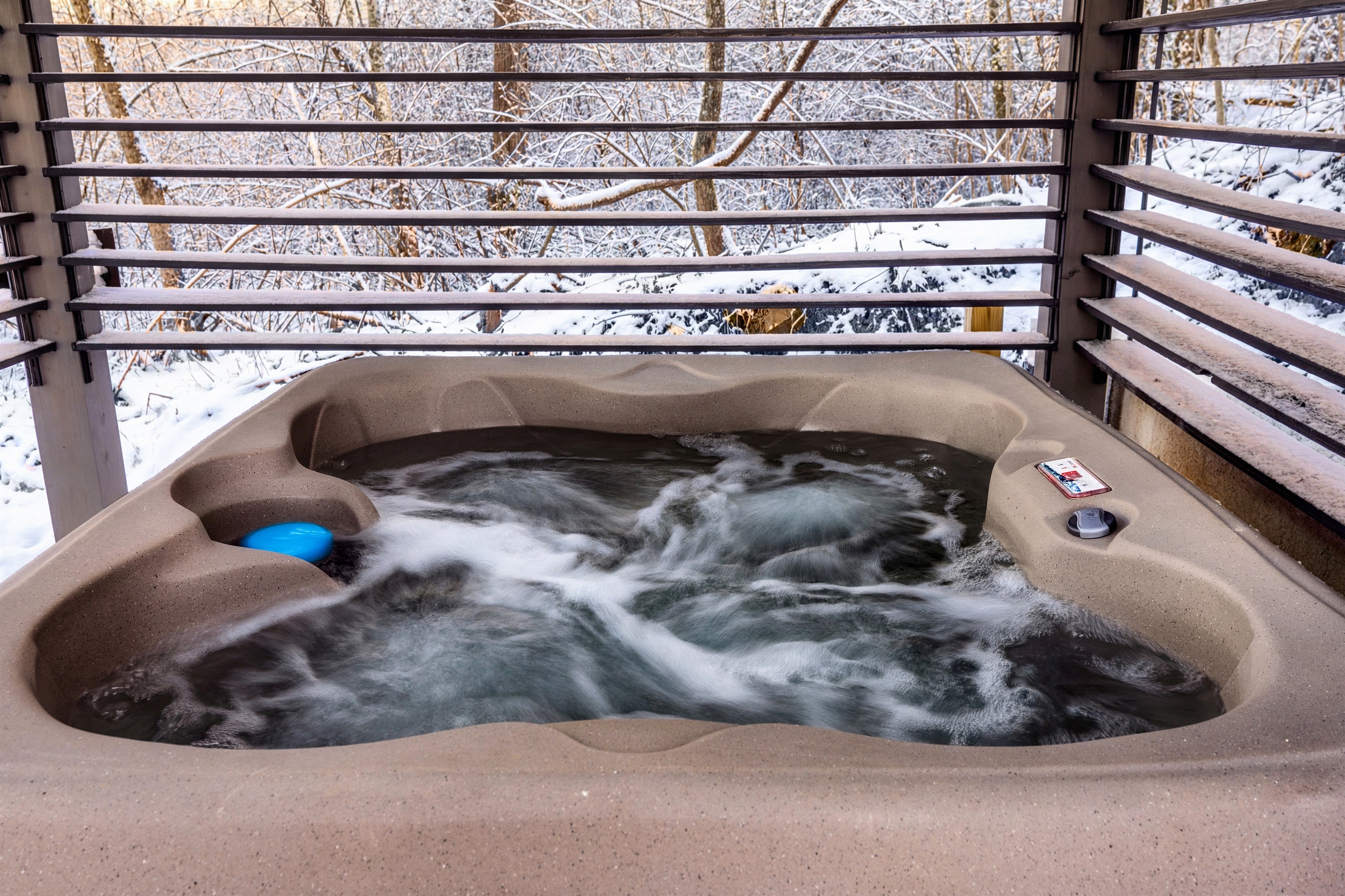 Hot tub with adjustable wooden side slats that close for privacy & decrease wind flow.