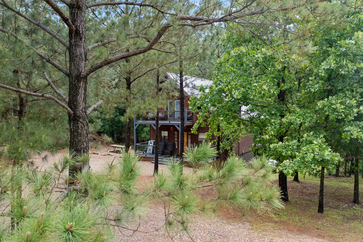 Exterior Escape: Nestled among tall pines, unwind on the spacious deck with nature's embrace!