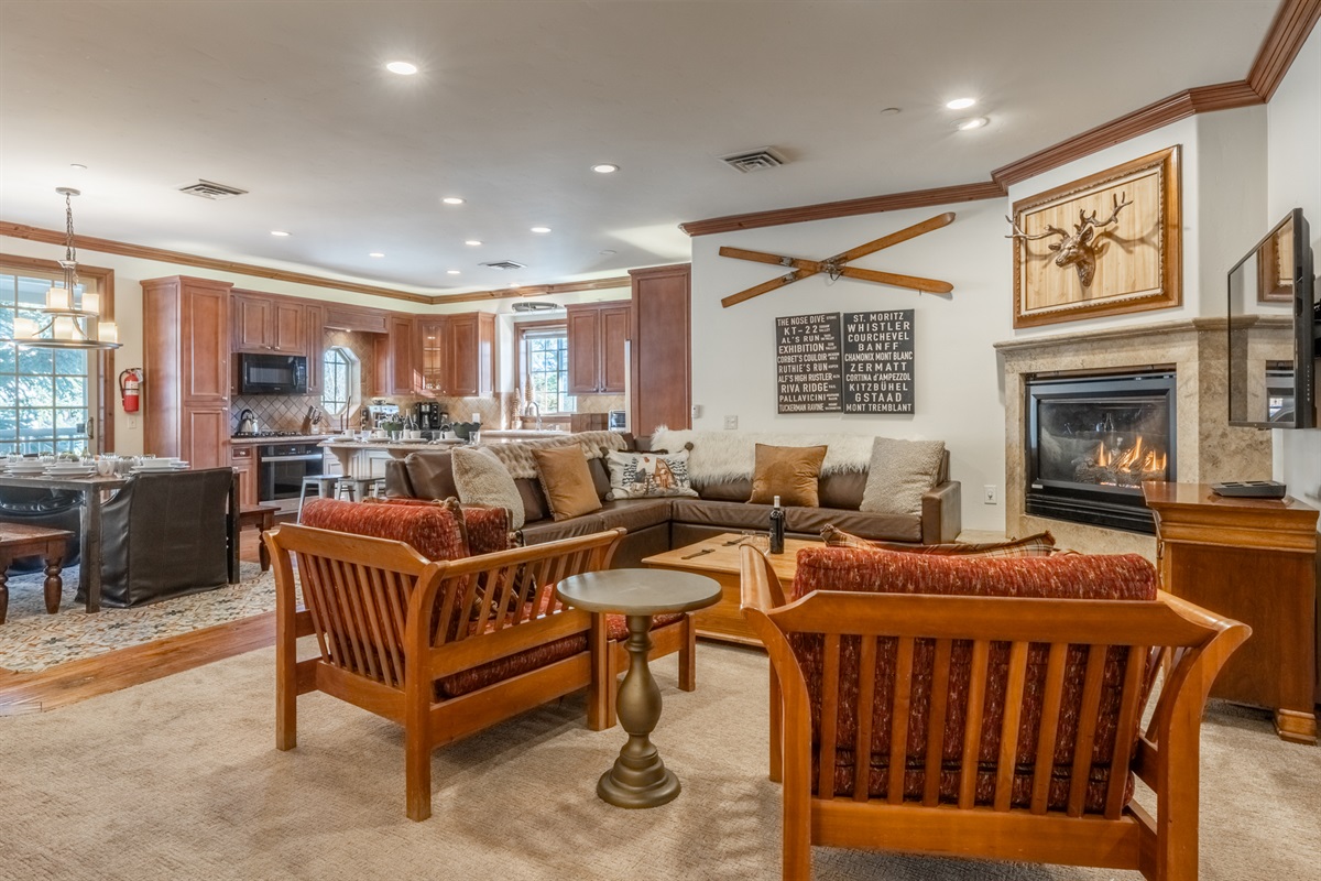 Flowing seamlessly from the dining area and ktichen, the Refined Rustic Retreat's living space offers plush seating, a gas fireplace, and a relaxed mountain lodge feel.