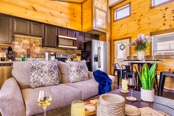 Gather around the cozy open concept living space at MistyOak, perfect for quality time with loved ones. Enjoy plush seating, a warm ambiance, and a fully equipped kitchen just steps away, making it easy to relax, dine, and create lasting memories together.