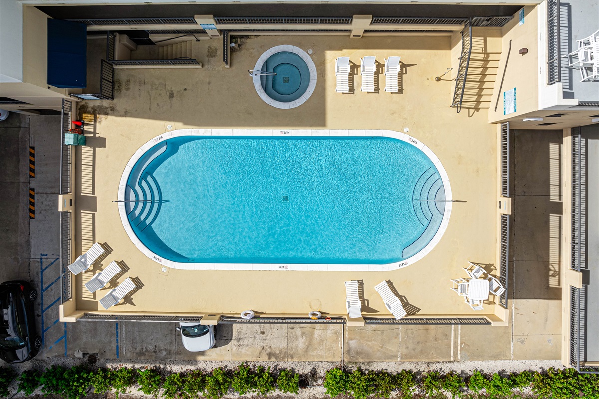 Relax on the deck by the large pool and hot tub