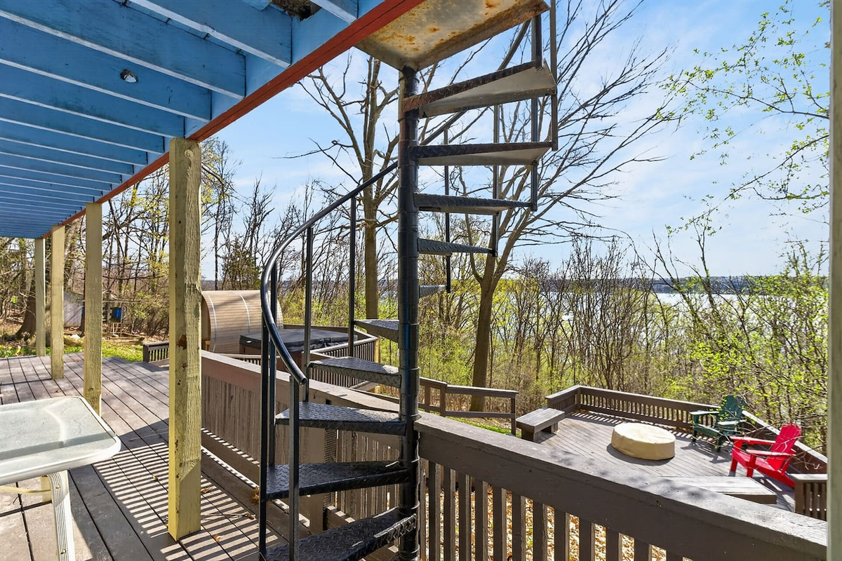 Spiral staircase connecting the upstairs balcony to the lower deck for easy access and seamless indoor-outdoor flow.