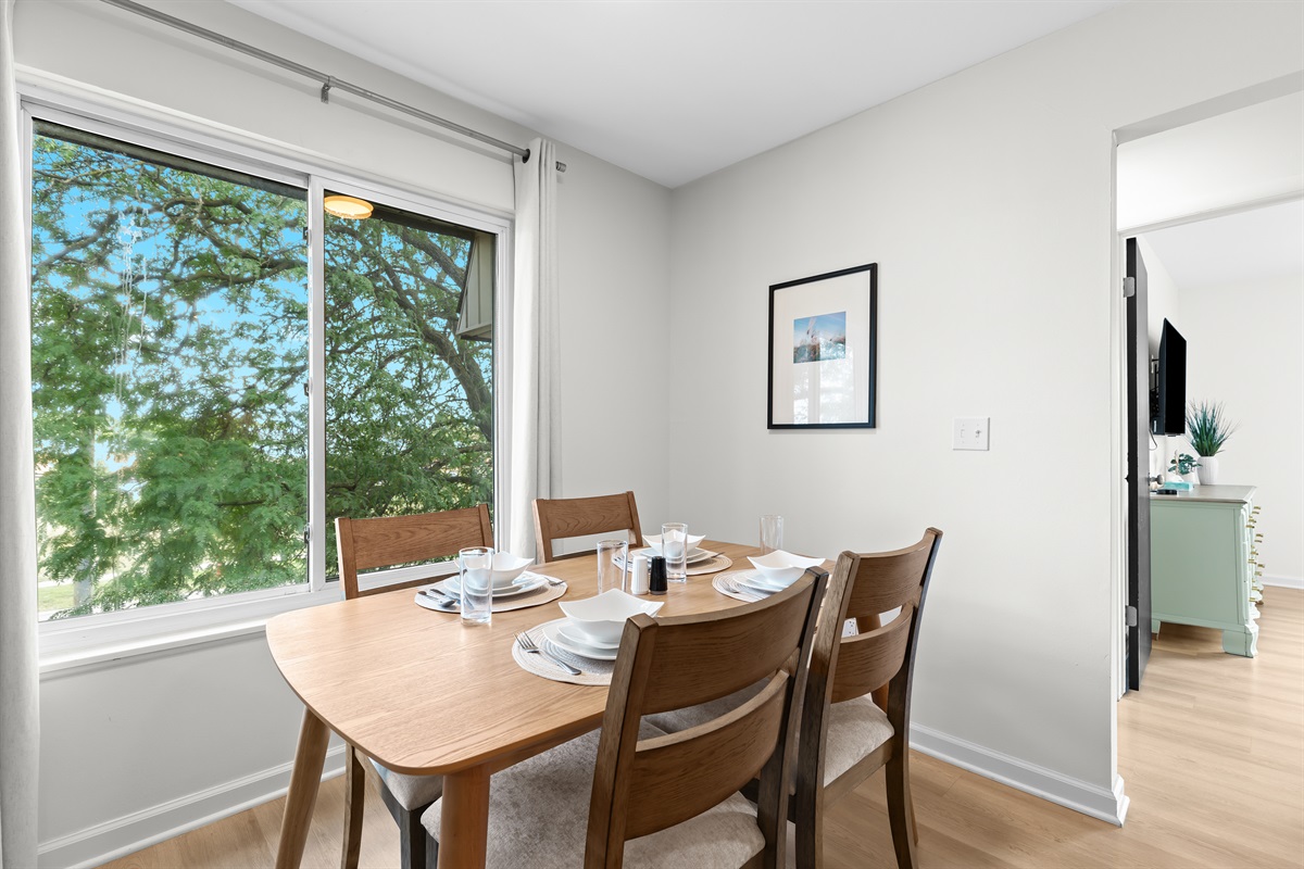 Bright dining nook with seating for four and a lovely outside view.