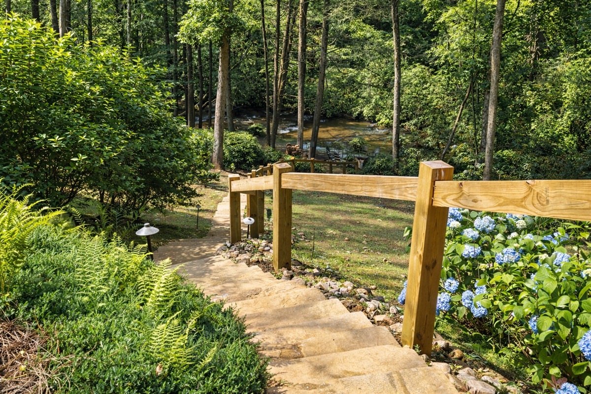 Stone steps lead you down to your own private creekside retreat 🌿Follow the path through lush greenery to a peaceful river setting perfect for morning coffee, afternoon lounging, or golden hour by the fire. Nature, tranquility, and laidback luxury!