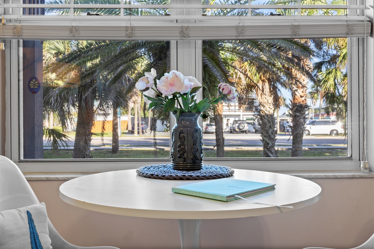 Bright and cozy coffee corner with a breezy view of outside palms.
