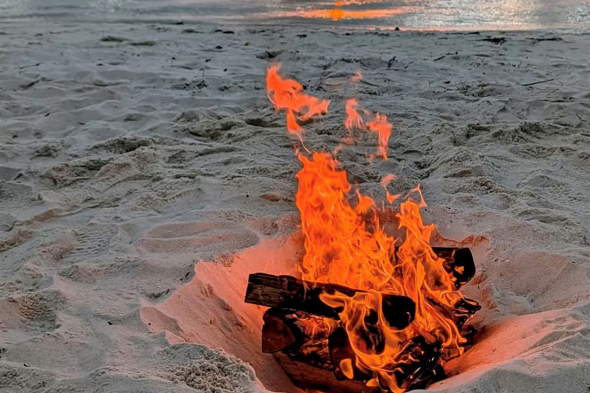 Sunset, waves, and a warm beach fire, the perfect ending to the day.