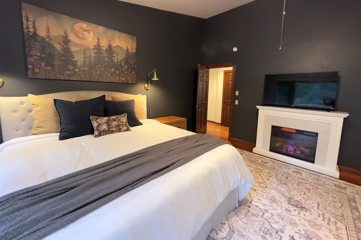 The primary bedroom on the main floor offers a cozy king bed, twin sleeper and twin trundle, electric fireplace and 50" Roku TV