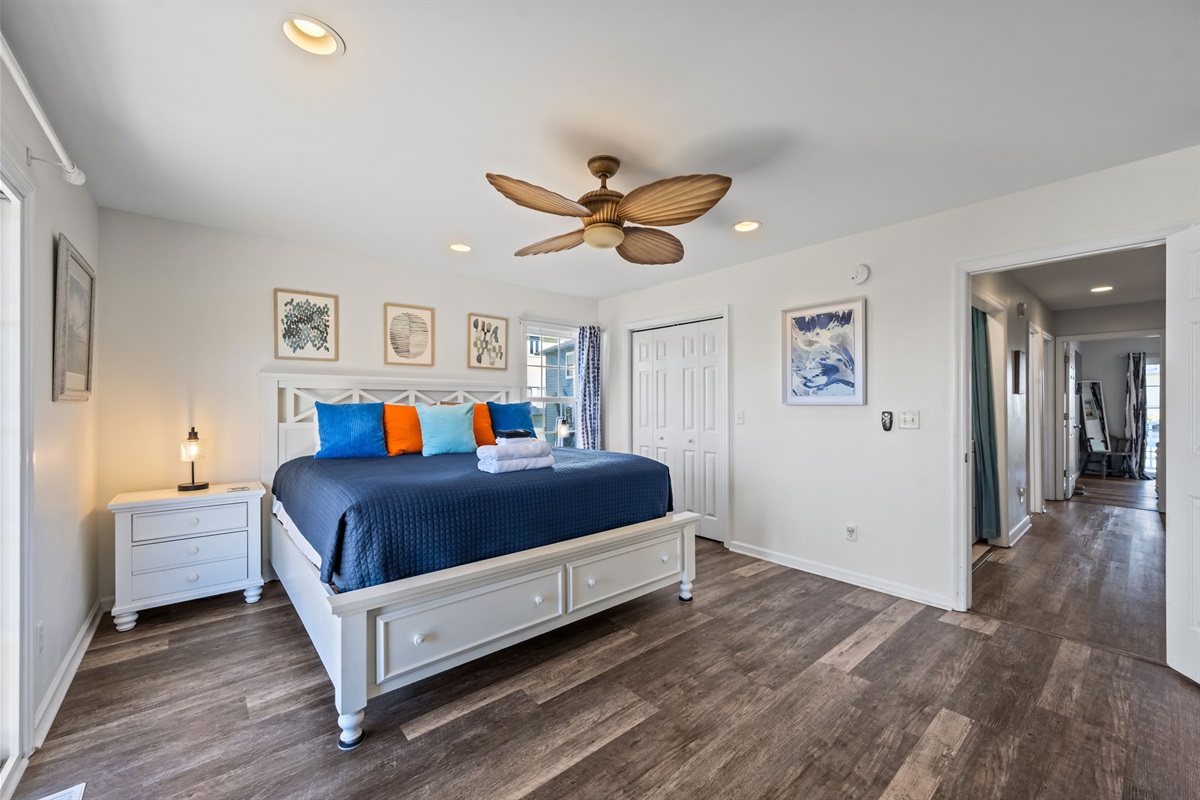 Bright master bedroom featuring a King-size bed, en-suite bathroom, smart TV, and walk-in closet.