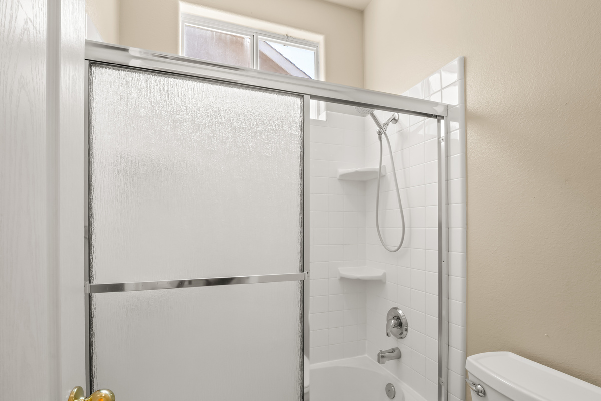 Refresh and recharge in this bright, clean bathroom featuring a shower/tub combination and plenty of natural light. Perfect for a relaxing soak after a day of work, sightseeing, or family adventures.