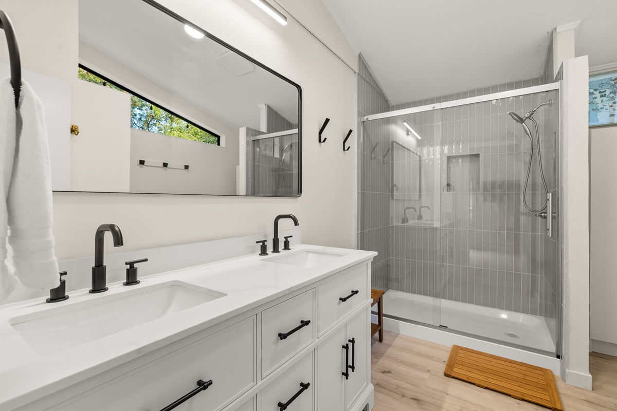 Indulge in a spacious, spa-inspired shower with floor-to-ceiling tile and a sleek handheld fixture