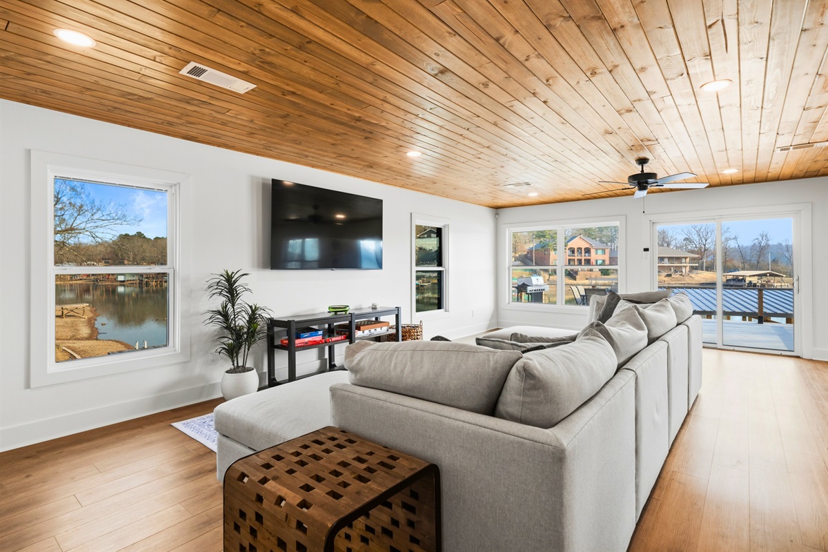 Large windows bring the outdoors in, giving the living area beautiful lake views and a light, airy feel that makes the whole space feel welcoming and relaxed.
