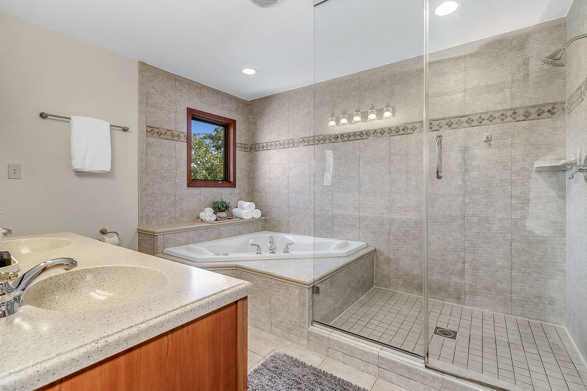 Upstairs Primary Bathroom Suite with jetted tub, walk-in shower, double vanity, and toilet with bidet. 