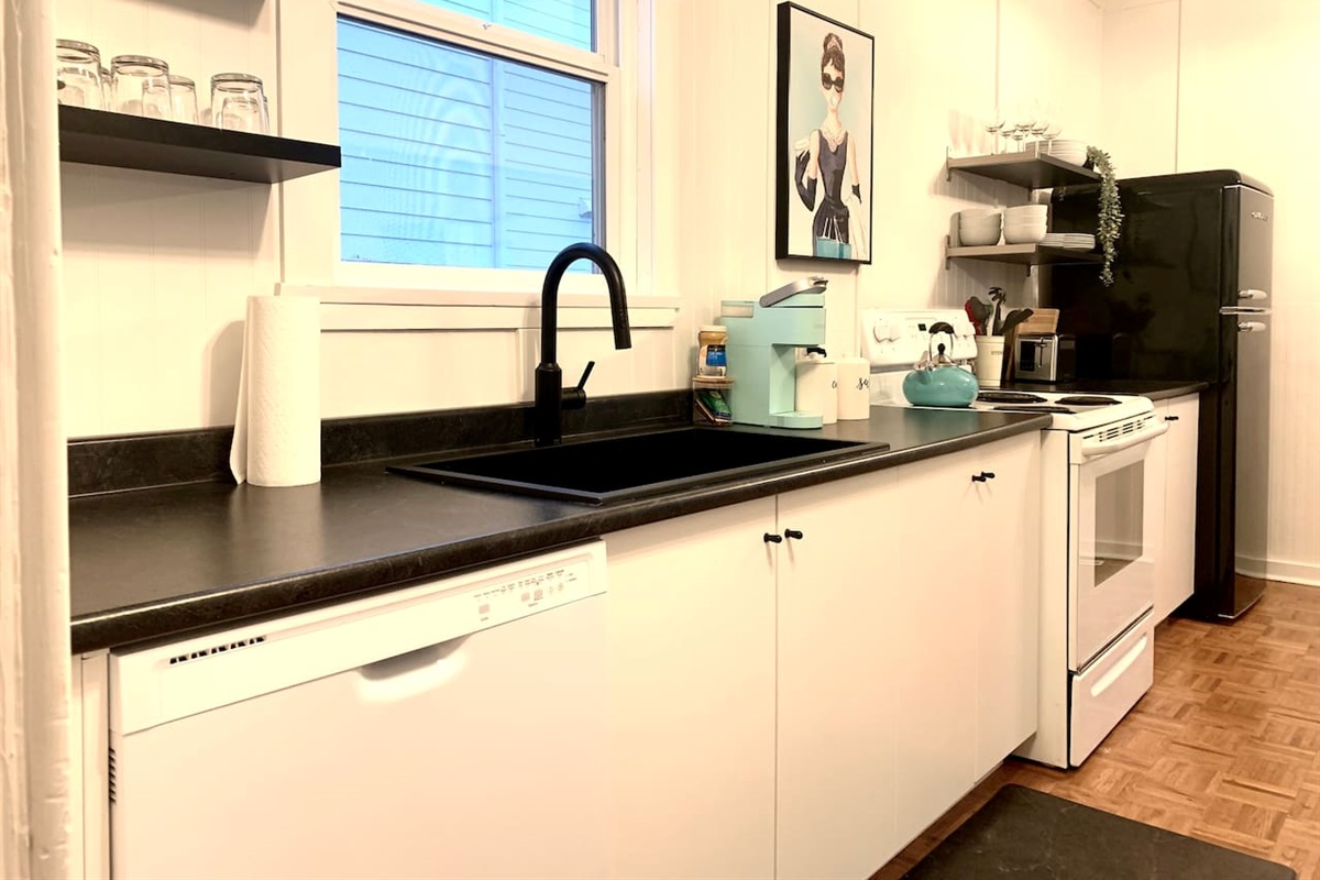 Fully equipped kitchen with stove, microwave, coffee maker, cookware, and dining essentials.