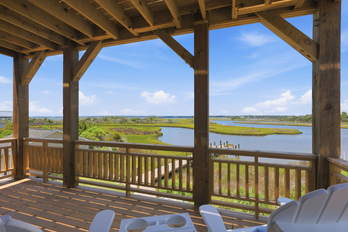 Unwind with unobstructed marsh vistas from the expansive outdoor living space, an ideal spot for morning coffee or watching colorful sunset skies