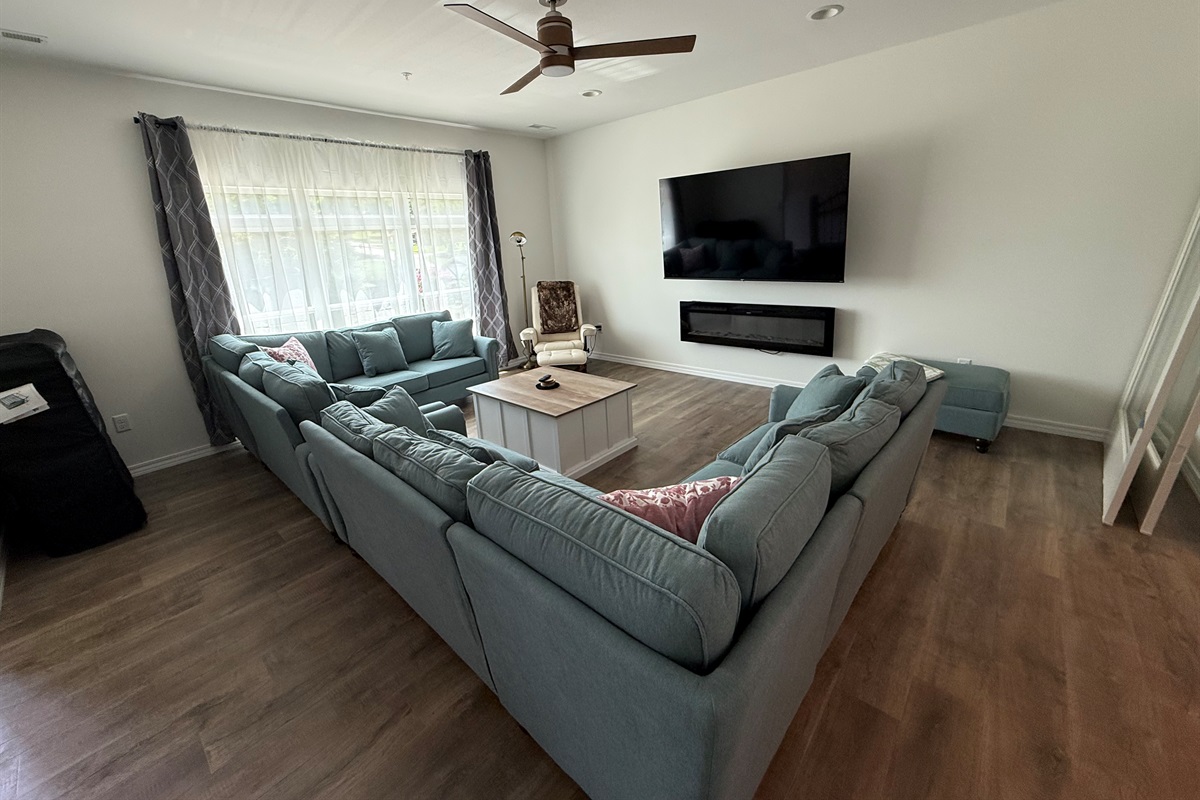 Large living room with seating for 12. Electric fireplace and 75” streaming TV
