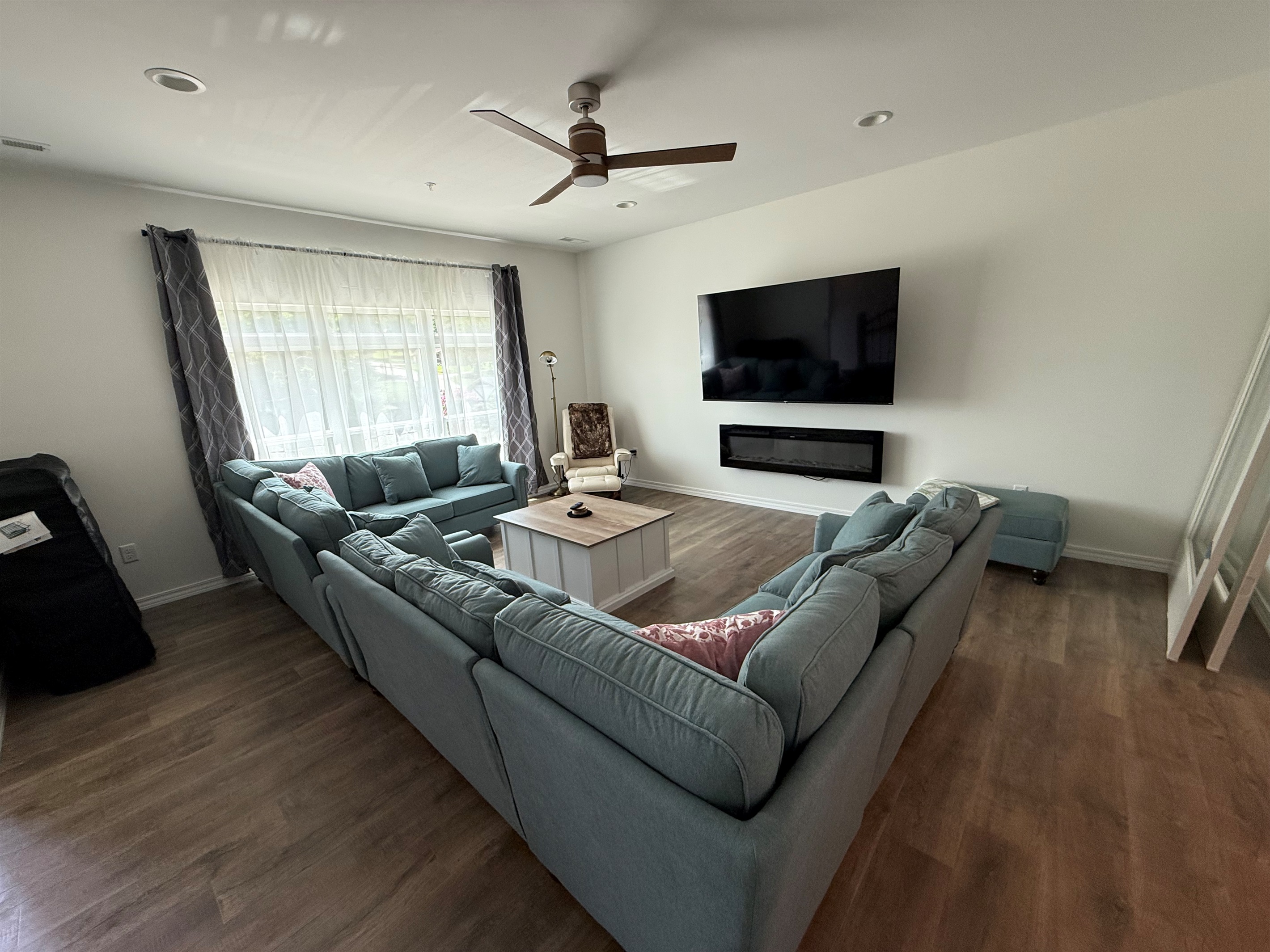 Large living room with seating for 12. Electric fireplace and 75” streaming TV