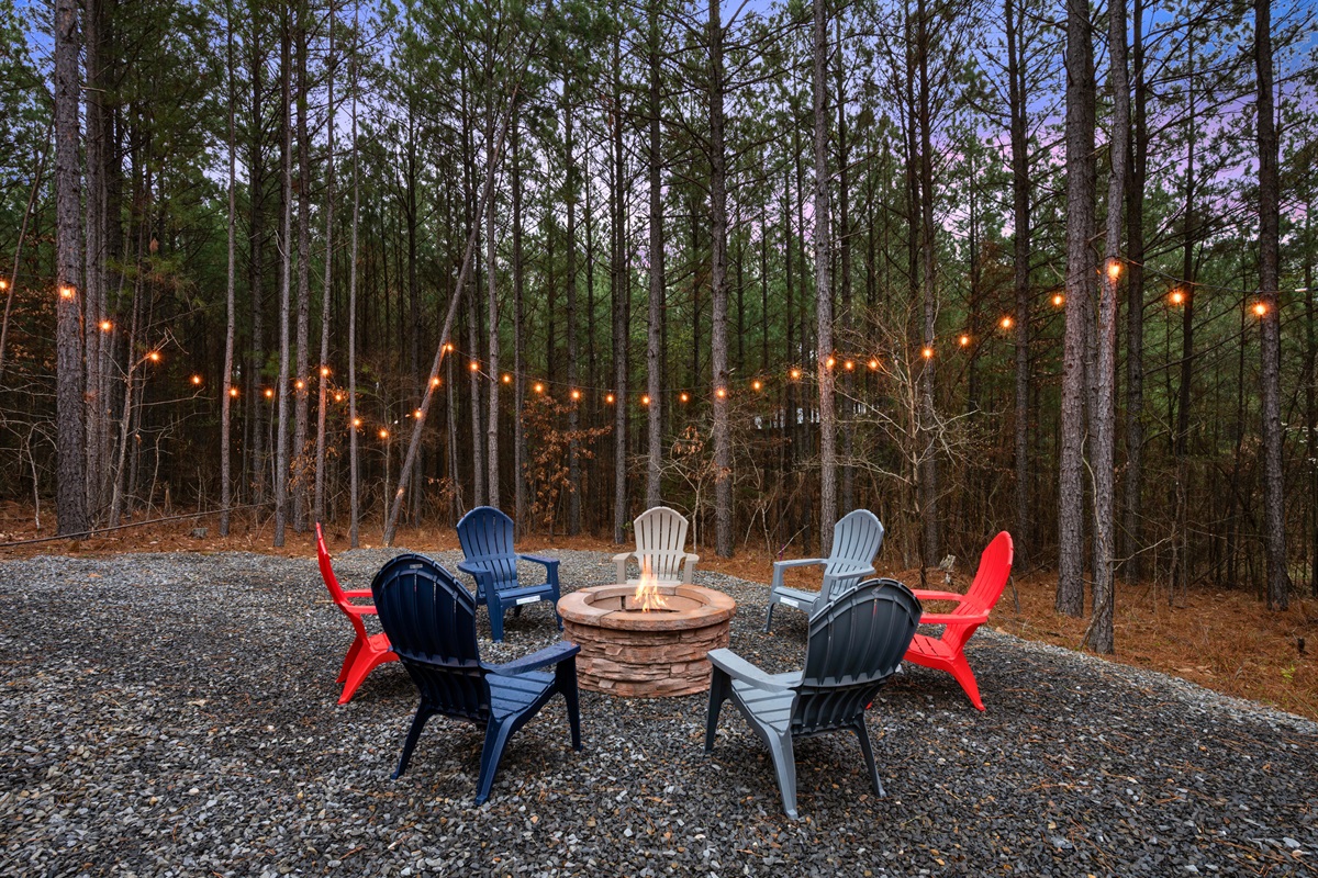 Gather around the outdoor fire pit where Adirondack chairs surround the flames, creating the perfect place for roasting marshmallows and sharing stories under the stars.