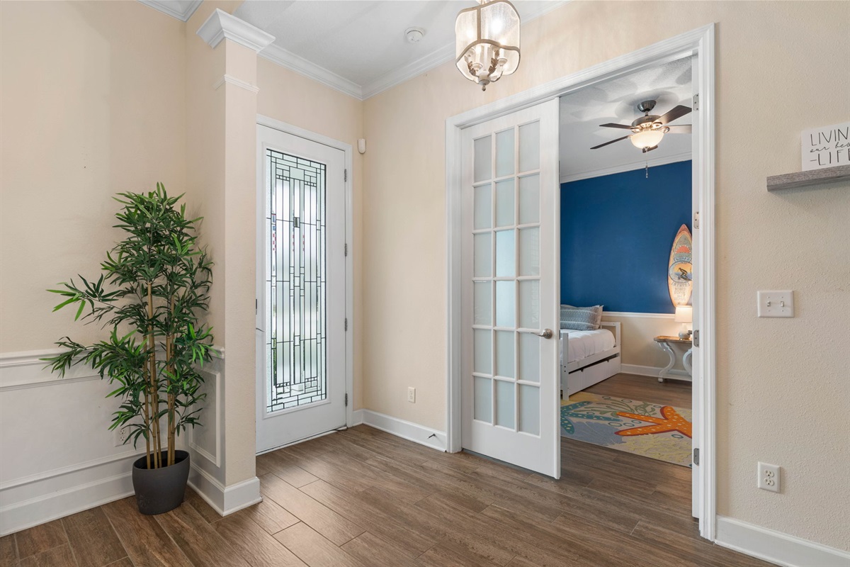 Step inside, drop your bags, and feel vacation settle in: a bright coastal entry, French doors to a surf-inspired room, and that instant sense that beach days, sleepy kids, and easy family memories are already beginning.