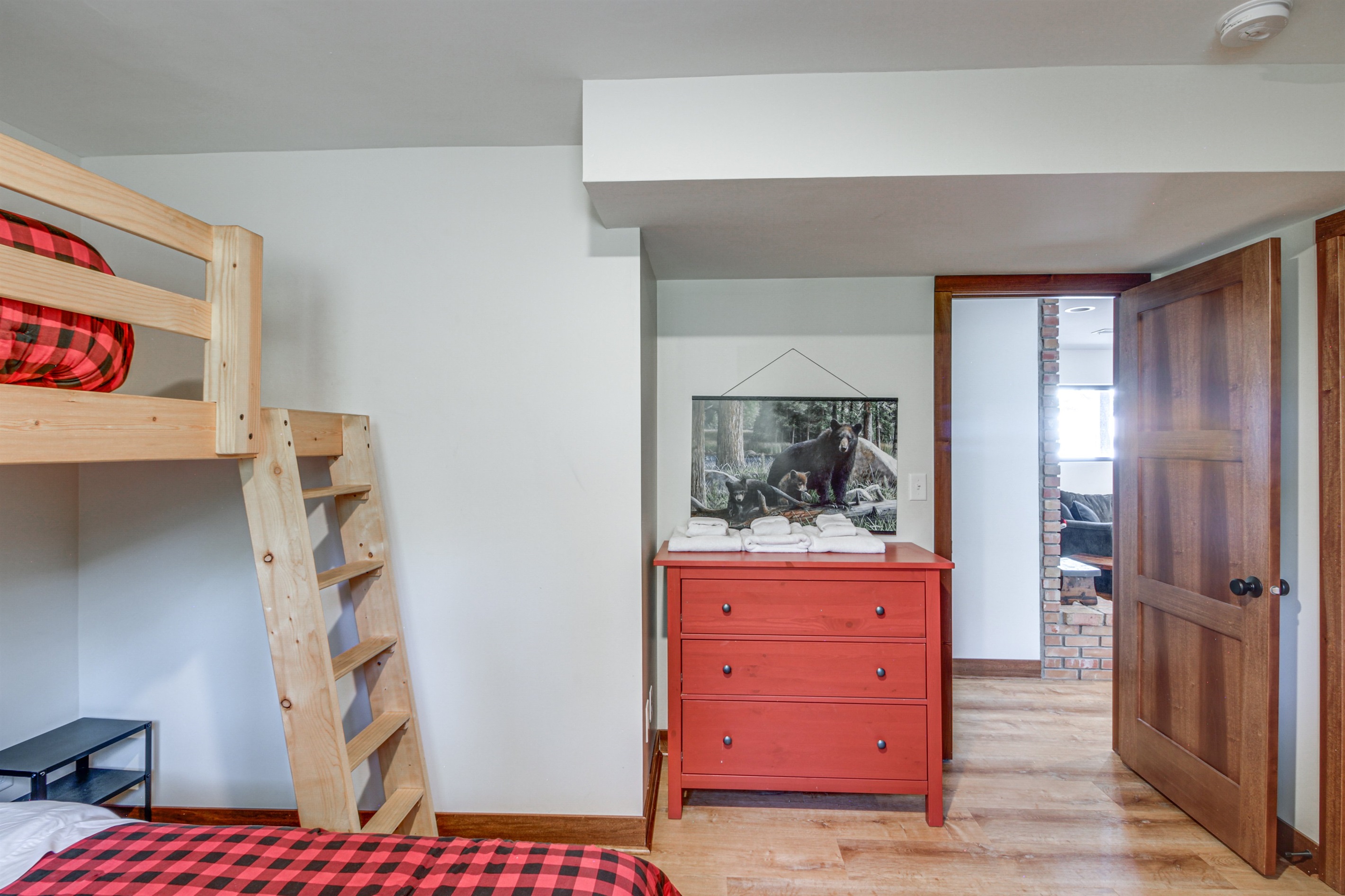 Cozy bunk room with custom wood bunks, fresh linens, and easy access to the main living area.