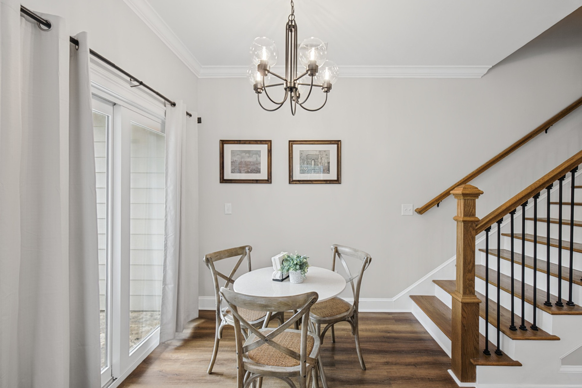 Dining nook beside the patio doors, with stairs to the bedrooms