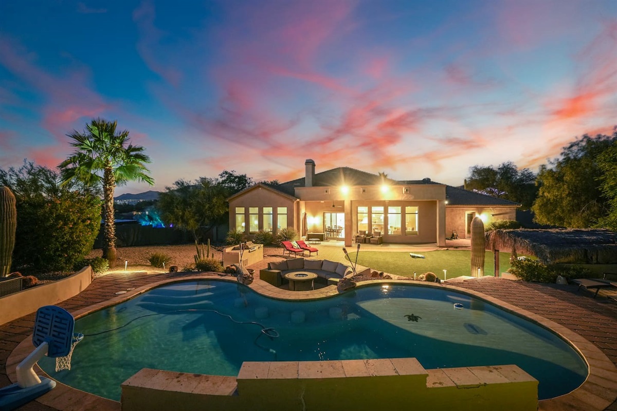 Evening pool ambiance with warm lighting and stunning sunset colors.