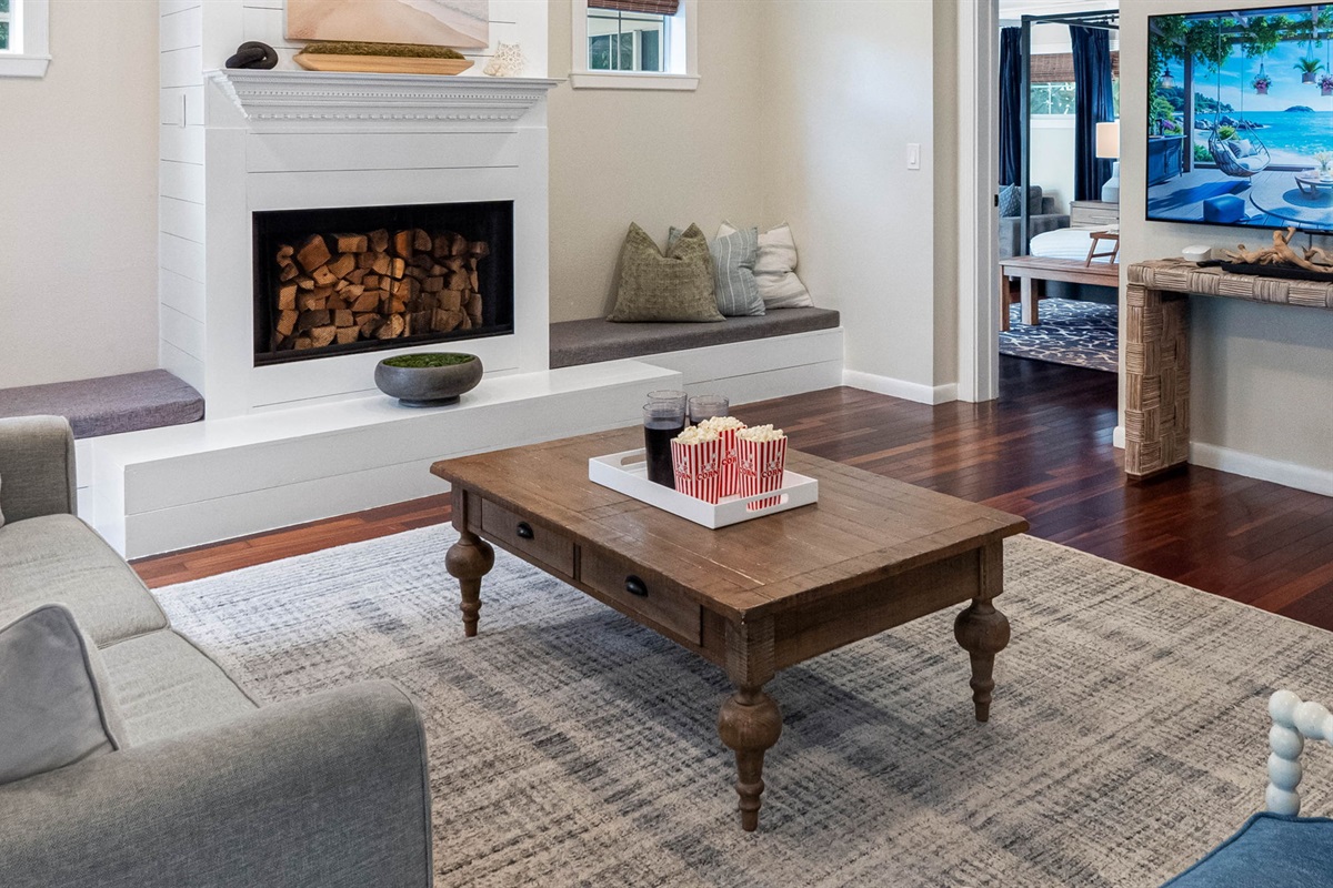 The shiplap fireplace, complete with built-in seating on each side, serves as a striking focal point of this charming living area.